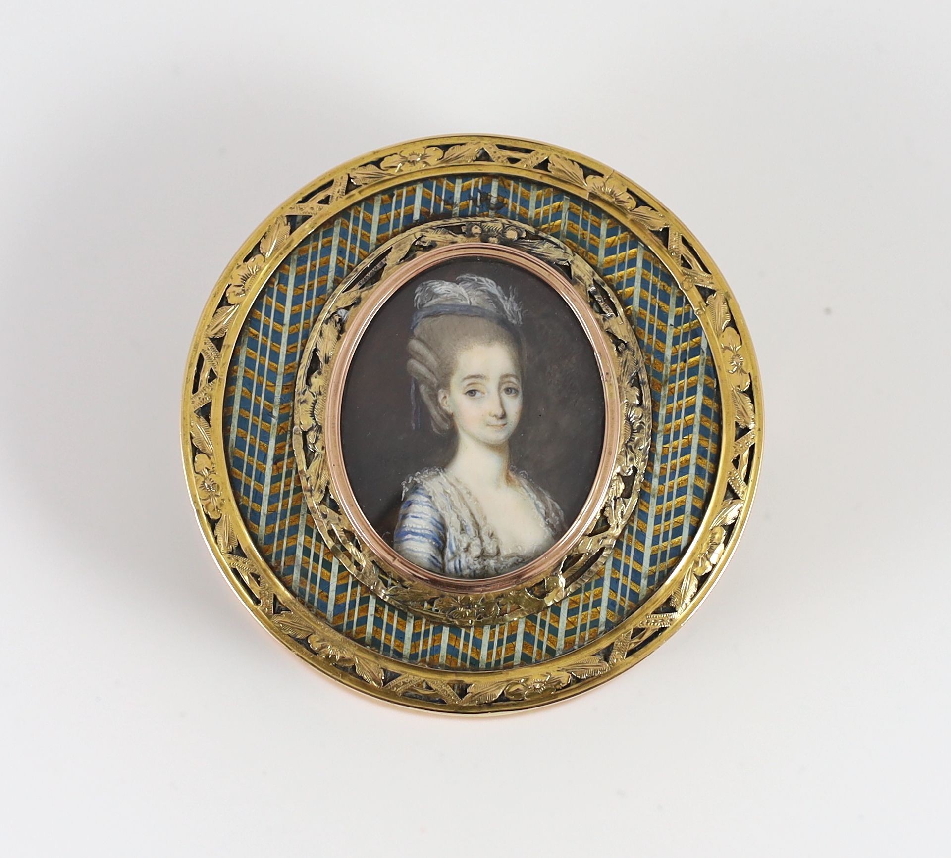 A late 18th century tortoiseshell boîte-à-miniature, the cove decorated with an inset portrait miniature of a young lady, mounted with pierced yellow metal borders 7.5cm diameter